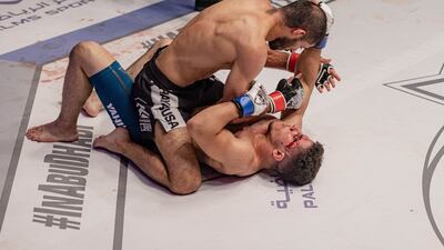 Nawras Abzakh has Sami Yahia pinned to the canvas.