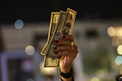 A demonstrator holds up US dollar bills during in a protest against Israeli Prime Minister Benjamin Netanyahu's government. EPA