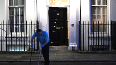 A worker cleans outside No 11 Downing Street before the budget. EPA