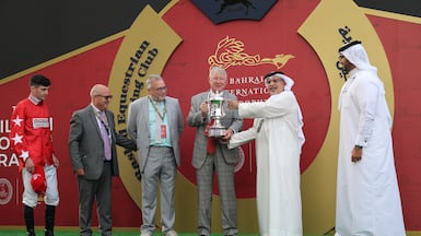 Former Manchester United manager Alex Ferguson is presented with the trophy after his horse Spirit Dancer won the Bahrain International Trophy. Picture: Supplied
