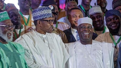 Incumbent President Muhammadu Buhari, centre, shakes hands with opposition presidential candidate Atiku Abubakar after signing an electoral peace accord in Abuja. AP Photo/Ben Curtis