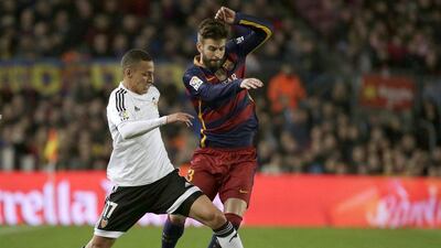 Barcelona defender Gerard Pique, right, fights for the ball with Valencia striker Rodrigo Moreno. Alberto Estevez / EPA
