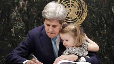 US secretary of state John Kerry holds his granddaughter Isabel Dobbs-Higginson as he signs the Paris Agreement on climate change at the United Nations headquarters in New York on April 22, 2016. Mark Lennihan / AP Photo