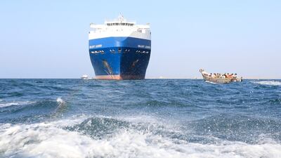 A boat sails past the Galaxy Leader cargo ship, which was seized by Yemen's Iran-backed Houthis rebels in the Red Sea. EPA