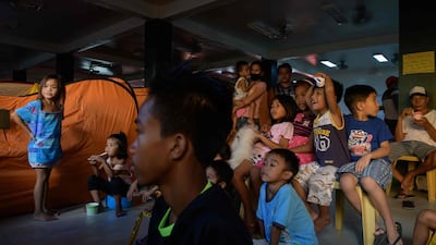 Children displaced by the eruption watch television at an evacuation centre in Santo Tomas. Philippine authorities warm the volcano could be "recharging" for a more powerful explosion. Ed Jones / AFP