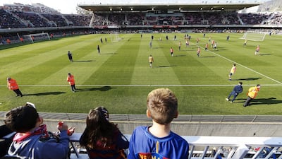 Children look on during an open training session for Barcelona. Alejandro Garcia / EPA