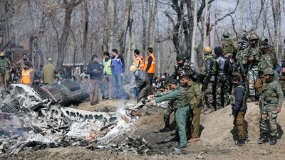 An Indian Air Force officer along with others inspects the wreckage of an Indian aircraft after it crashed in Budgam on the outskirts of Srinagar, Indian-administered Kashmir. AP Photo