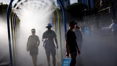 Fans walk through a water mist system at Melbourne Park to cool down during the Australian Open. Reuters