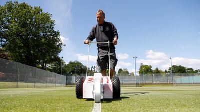 Head groundsman Paul Bishop cuts the grass on the courts at St George’s Hill Lawn Tennis Club in Weybridge as they prepare to reopen, following an easing of restrictions in the UK after the outbreak of the coronavirus. Reuters