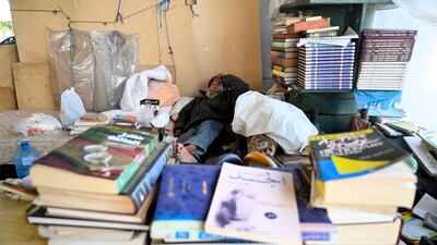 The stacks of books served as walls that surrounded the place where he lived.
