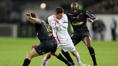 Lionel Messi in action with Lens' Yannick Cahuzac. Reuters