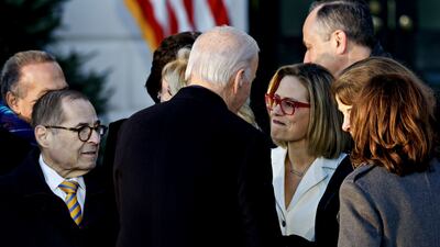 Mr Biden speaks with Ms Sinema during the ceremony. Bloomberg