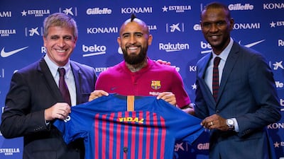 New Barcelona signing Arturo Vidal, centre, alongside Barcelona's third vice president Jordi Mestre, left, and sports manager Eric Abidal at his unveiling earlier this month. EPA
