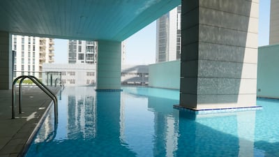The building has a partially shaded communal swimming pool