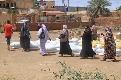 Sudanese receive aid at Al Omada neighbourhood of Omdurman. AFP