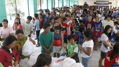 Residents queue for relief goods at an evacuation centre in Marikina, Manila.