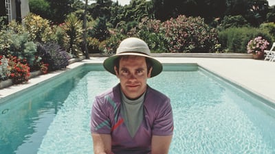 Elton John, in a purple sports kit and a safari-style hat, poses by the pool at his villa in Saint-Tropez in the south of France in January 1982. Getty Images