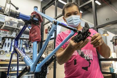 A mechanic at Pedal puts together a bicycle that features poems by Ruler of Dubai Sheikh Mohammed bin Rashid. Photo: Antonie Robertson / The National