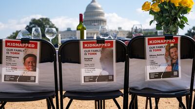 An empty shabbat table with pictures of hostages who are still being held. Reuters