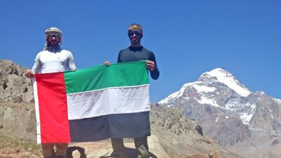 Yousef Al Gurg, left, and Abdulla Al Muhairbi hold the UAE flag during their ascent to the top of Mount Aconcagua. Courtesy Think Up