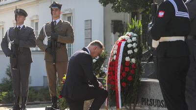 Mr Duda lays a wreath in front of the Jozef Pilsudski monument in Warsaw. EPA