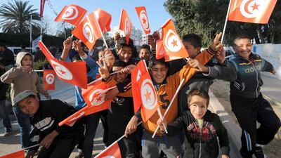 Tunisian children wave the national flag as they gather to mark the third anniversary of the uprising that toppled deposed president Zine El Abidine Ben Ali in Mohamed Bouazizi Square. Fethi Belaid / AFP