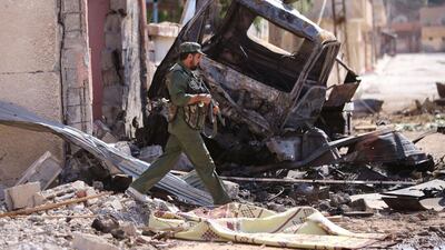 A member if the Syrian regime forces walks near a destroyed vehicle in the northeastern Syrian city of Hasakeh. Youssef Karwashan / AFP