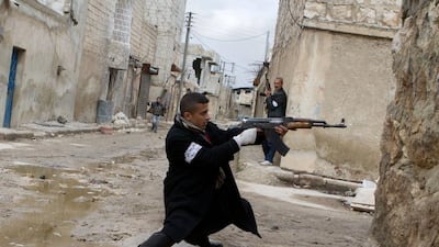 A Syrian rebel aims his weapon during clashes with government forces in the streets near Aleppo’s international airport in northern Syria. Stephen Boitano / AFP