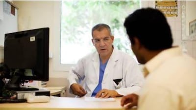 Dr Mohsen El Mekresh speaks to a patient in his examination room at Mafraq Hospital. Christopher Pike / The National
