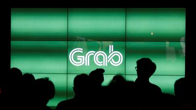 FILE PHOTO - People wait for the start of ride-hailing company Grab's fifth anniversary news conference in Singapore June 6, 2017. REUTERS/Edgar Su/File Photo