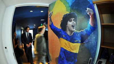 People walk by a room with the door decorated with a painting of Diego Maradona in a suite on the 11th floor of the Boca Hotel on April 19, 2012 in Buenos Aires. The five star football hotel --the first of its type in the world-- opened this week and is scheduled for mid-year to host the football team, which will concentrate there with two floors tailored to their needs. AFP PHOTO / DANIEL GARCIA / AFP PHOTO / DANIEL GARCIA