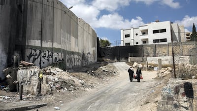 Palestinian women walk beneath Israel's separation barrier on August 27, 2018. Heidi Levine for The National