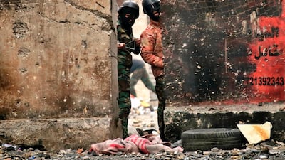 Policemen use slingshots to fire stones towards anti-government protesters during clashes on Rasheed Street in Baghdad. AP Photo