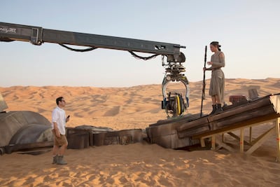 A handout photo of Star Wars: The Force Awakens showing L to R: Director JJ Abrams with actress Daisy Ridley (Rey) on set. Courtesy Disney
