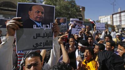 A protester holds up a poster of Yemen's former president Abdrabu Mansur Hadi during an anti-Houthi demonstration in Sanaa on February 21, 2015. Mr Hadi fled his official residence after weeks of house arrest by the Houthi militia on Saturday. Khaled Abdullah / Reuters
