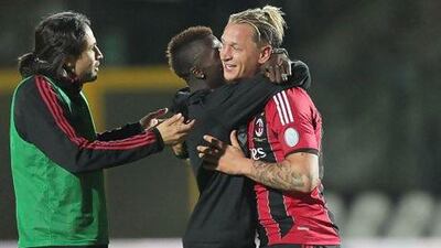 Philippe Mexes, right, is hugged by M'Baye as Mario Yepes, left, joines the celebration after AC Milan victory to stay third in the table at season's end.