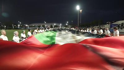 Healthcare workers display a vast UAE flag weighing more than 200kg. Photo: Burjeel Holdings