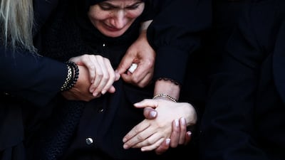 The relatives of Maj Mohammad Farhat are comforted by friends at a memorial in Beirut. Reuters