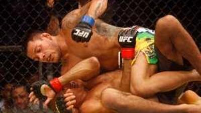 Rafael Dos Anjos throws a punch while on top of Terry Etim during their bout last night.