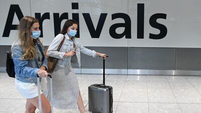 Passengers wearing a face mask or covering due to the COVID-19 pandemic, arrive at Heathrow airport, west London, on July 10, 2020. The British government on Friday revealed the first exemptions from its coronavirus quarantine, with arrivals from Germany, France, Spain and Italy no longer required to self-isolate from July 10. Since June 8, it has required all overseas arrivals -- including UK residents -- to self-quarantine to avoid the risk of importing new cases from abroad. / AFP / DANIEL LEAL-OLIVAS
