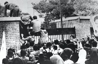 Iranian students climb over the wall of the US embassy in Tehran on November 4, 1979. IRNA / AFP