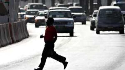A pedestrian crosses Airport Road outside Carrefour in Abu Dhabi yesterday, near the site of the accident.