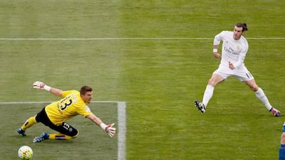 epa05262084 Real Madrid's Welsh midfielder Gareth Bale (R) scores his goal in front of goalkeeper Vicente Guaita (C) of Getafe FC during their Primera Division soccer match played at Coliseum Alfonso Perez stadium in Getafe, Madrid, Spain on 15 April 2016. EPA/JuanJo Martin