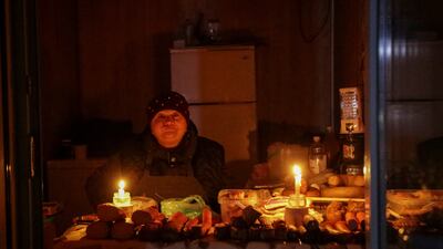 A vendor waits for customers in a small store that is lit with candles during a power outage after critical civil infrastructure was hit by Russian missile attacks, as Russia's invasion of Ukraine continues. Reuters.