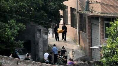 Police carry away the body of Zhou Kehua, the fugitive serial killer and armed robber, from the spot he was shot dead, in Chongqing municipality.