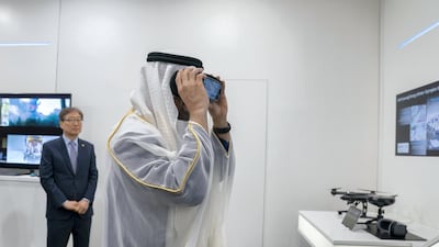 Sheikh Mohamed looks through a VR headset.