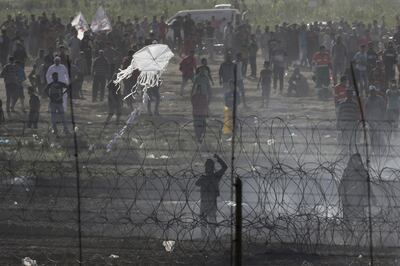 epa06794381 A view from the Israeli side of the border showsshows a young Palestinian demonstrator flying a kite, of which many were carrying Molotow cocktails, during their demonstration on the border fence between Gaza and Israel, in southern Israel, 08 June 2018, as Palestinians mark the 'Naksa Day', or Al Quds Day (Jerusalem Day) and the last Friday prayer of the Muslims' holy month of Ramadan. EPA/ABIR SULTAN