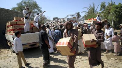 Yemenis carry boxes of food aid provided by the UAE Red Crescent for displaced people in the city of Marib in November 2015. Abdullah Al Qadry / AFP