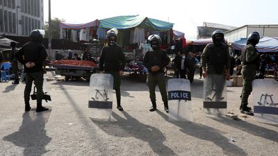 Police forces stand guard as Iraqis protest at the site of a suicide bomb attack at a popular market in Baghdad, Iraq, on January 21, 2021. EPA