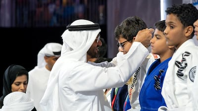 Sheikh Mohammed bin Zayed Al Nahyan Crown Prince of Abu Dhabi Deputy Supreme Commander of the UAE Armed Forces (L), awards a medal to a participant during the Abu Dhabi Jiu-Jitsu Festival. Mohamed Al Hammadi / Crown Prince Court - Abu Dhabi